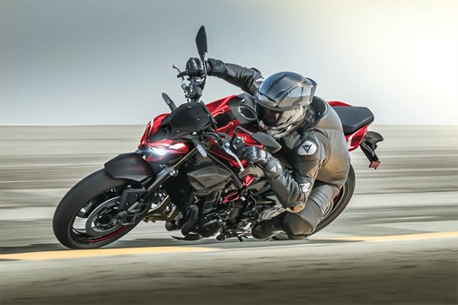 Side angle of a person aggressively turning a motorcycle on the street. opens in a new window