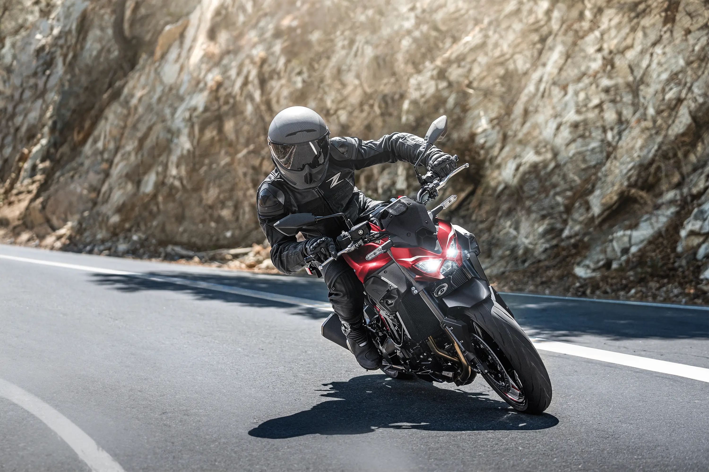 Three-quarter front angle of a person riding a motorcycle on a highway.