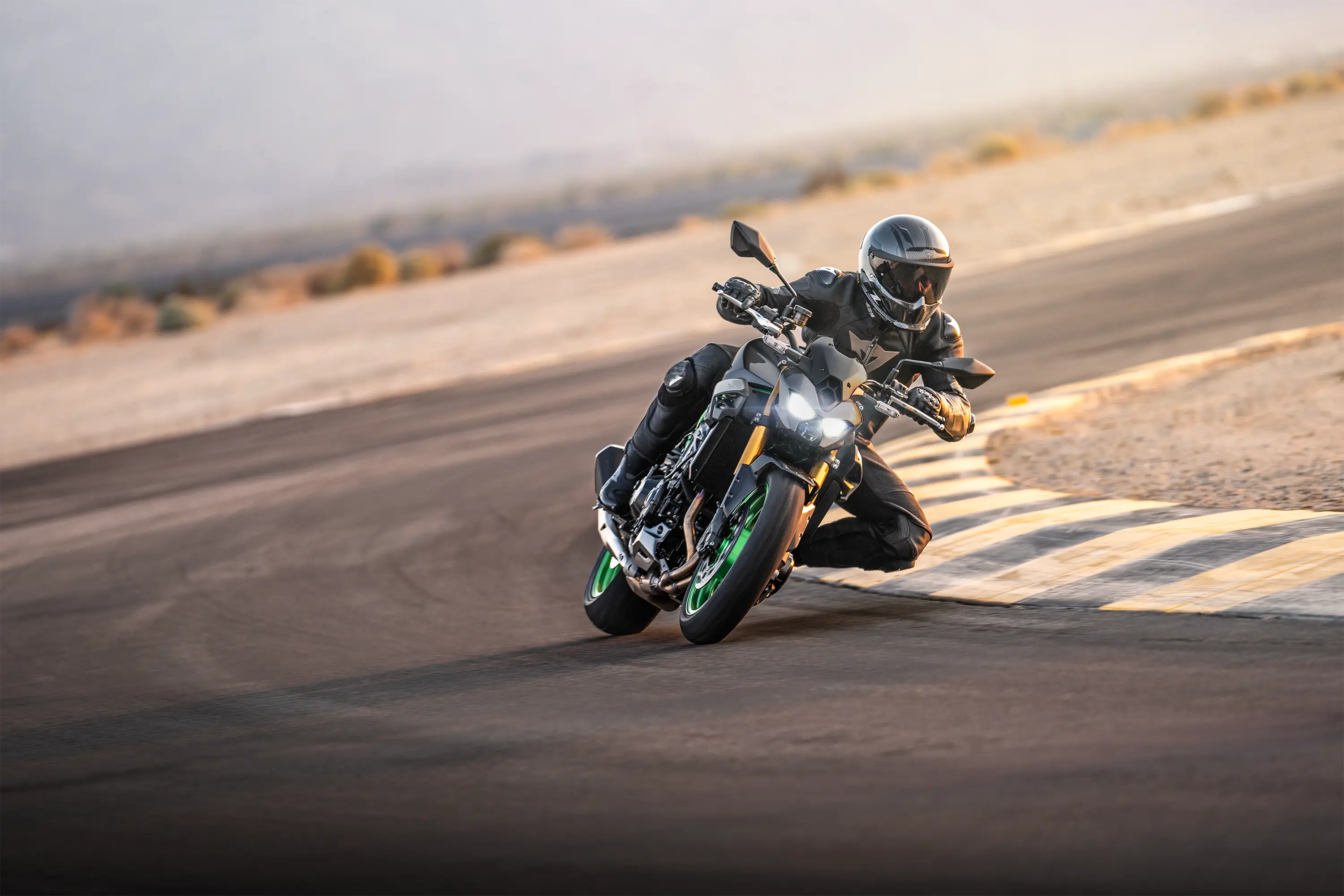 Three-quarter front angle of a person riding a motorcycle on a track.