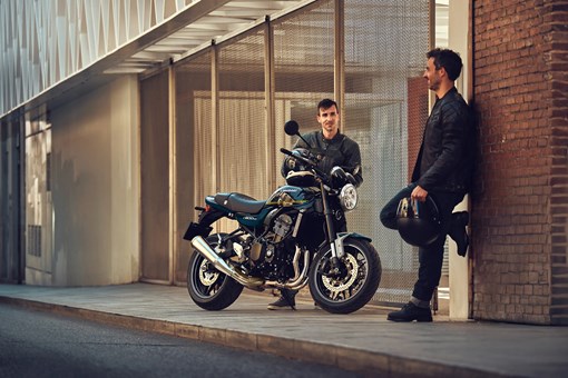 Three-quarter front angle of a motorcycle parked near two people. opens in a new window