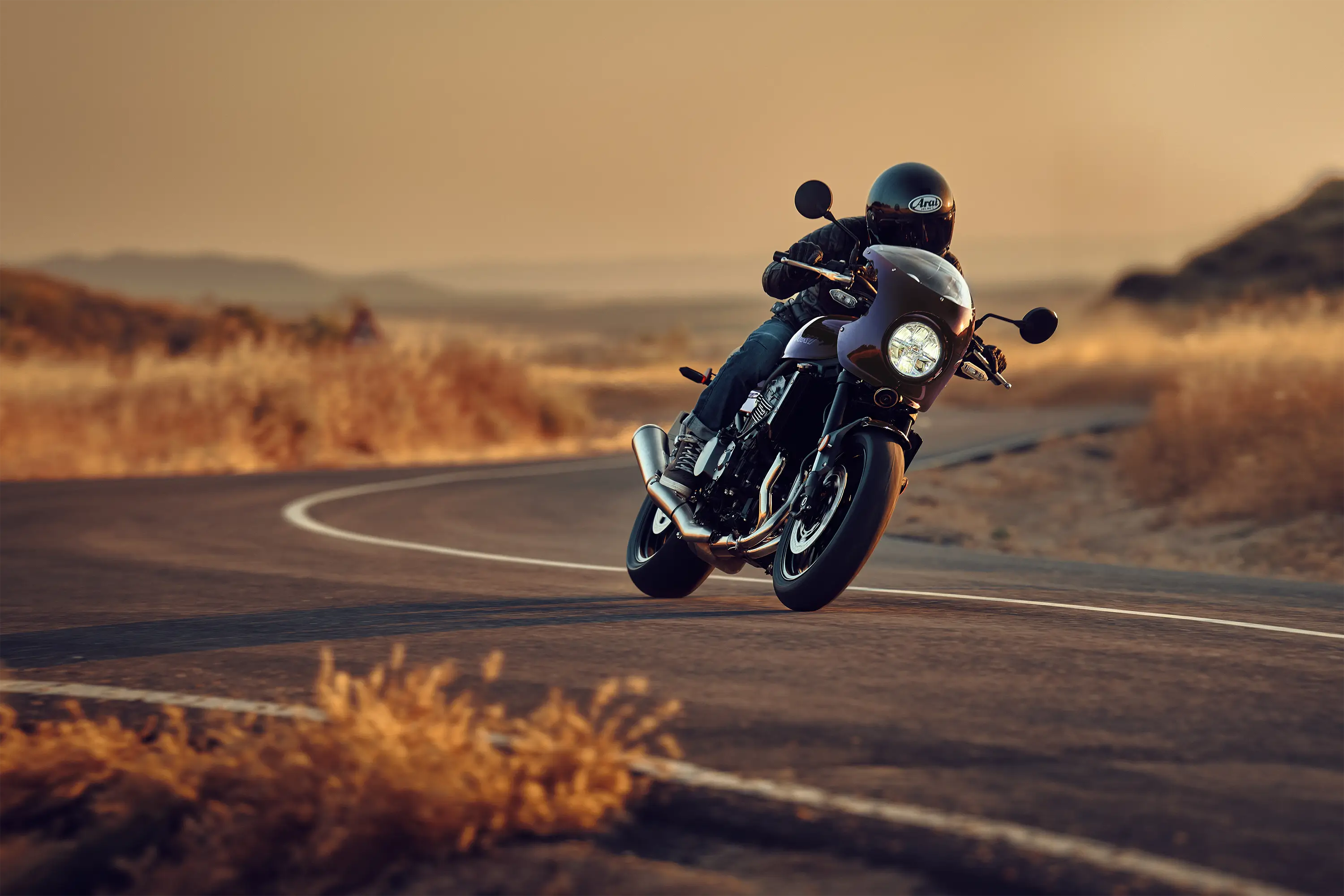 Three-quarter front angle of a person riding a motorcycle on a highway.