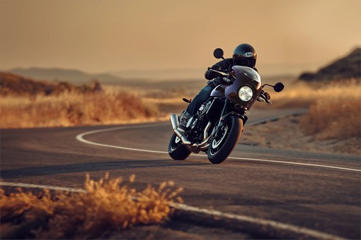 Three-quarter front angle of a person riding a motorcycle on a highway. opens in a new window
