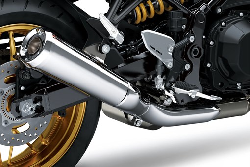 Close-up of the exhaust of a motorcycle staged in a white studio background. opens in a new window