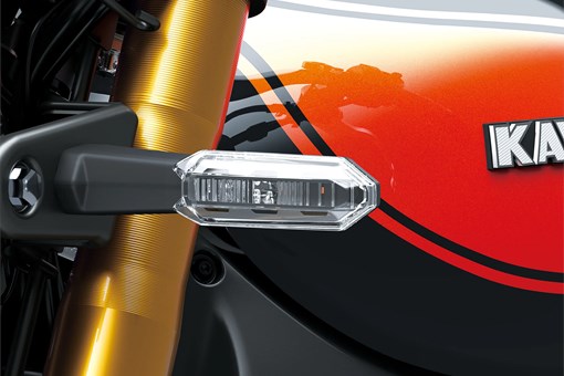 Close-up of the reflective light of a motorcycle staged in a white studio background. opens in a new window