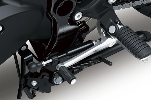 Close-up of the foot peg of a motorcycle staged in a white studio background. opens in a new window