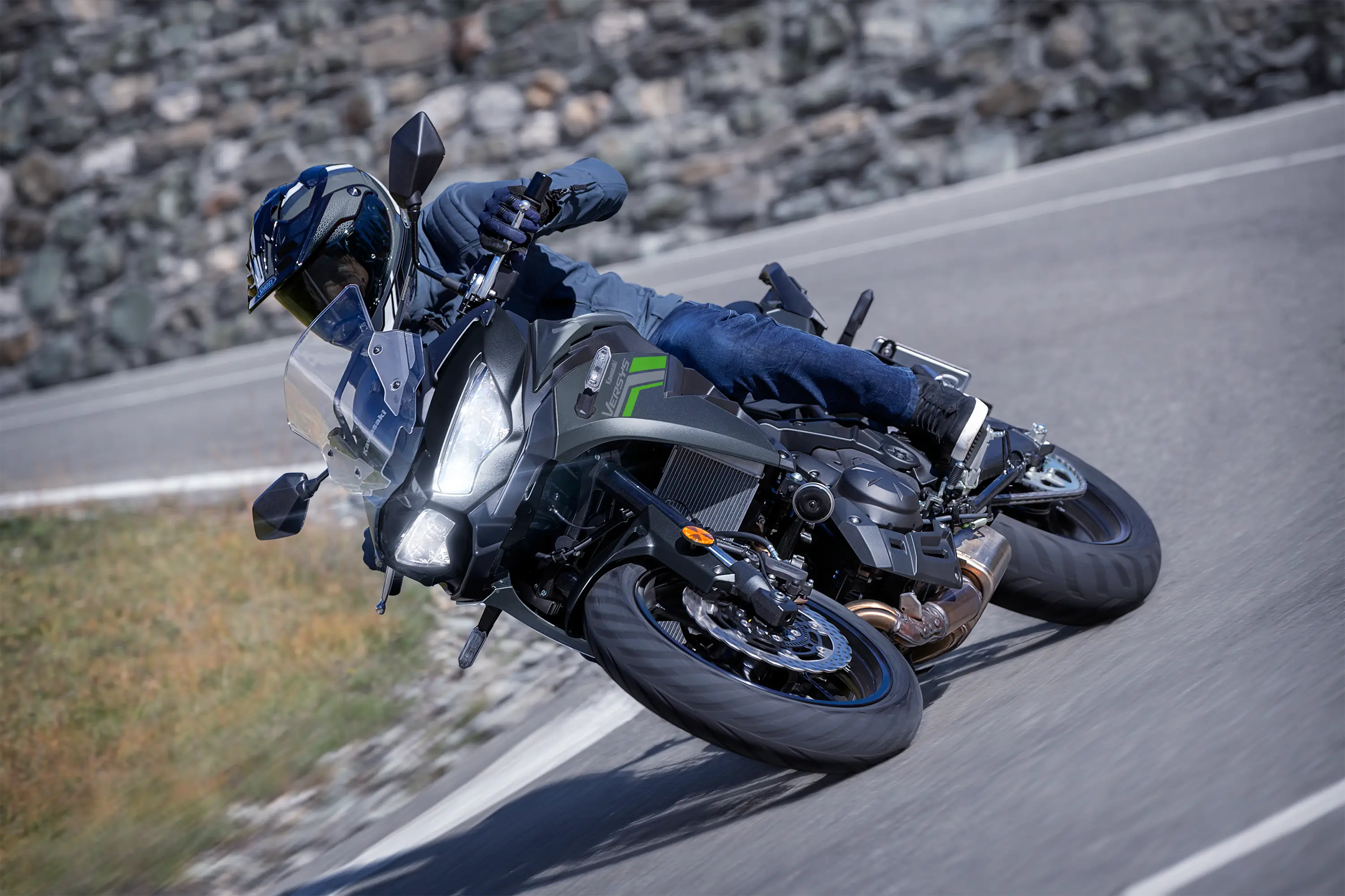 Three-quarter front angle of a person riding a motorcycle on a highway.
