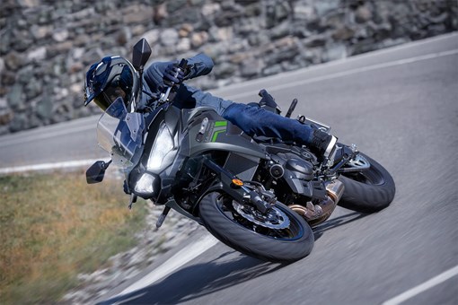 Three-quarter front angle of a person riding a motorcycle on a highway. opens in a new window
