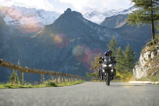 Front angle of a person riding a motorcycle on a mountain highway. opens in a new window