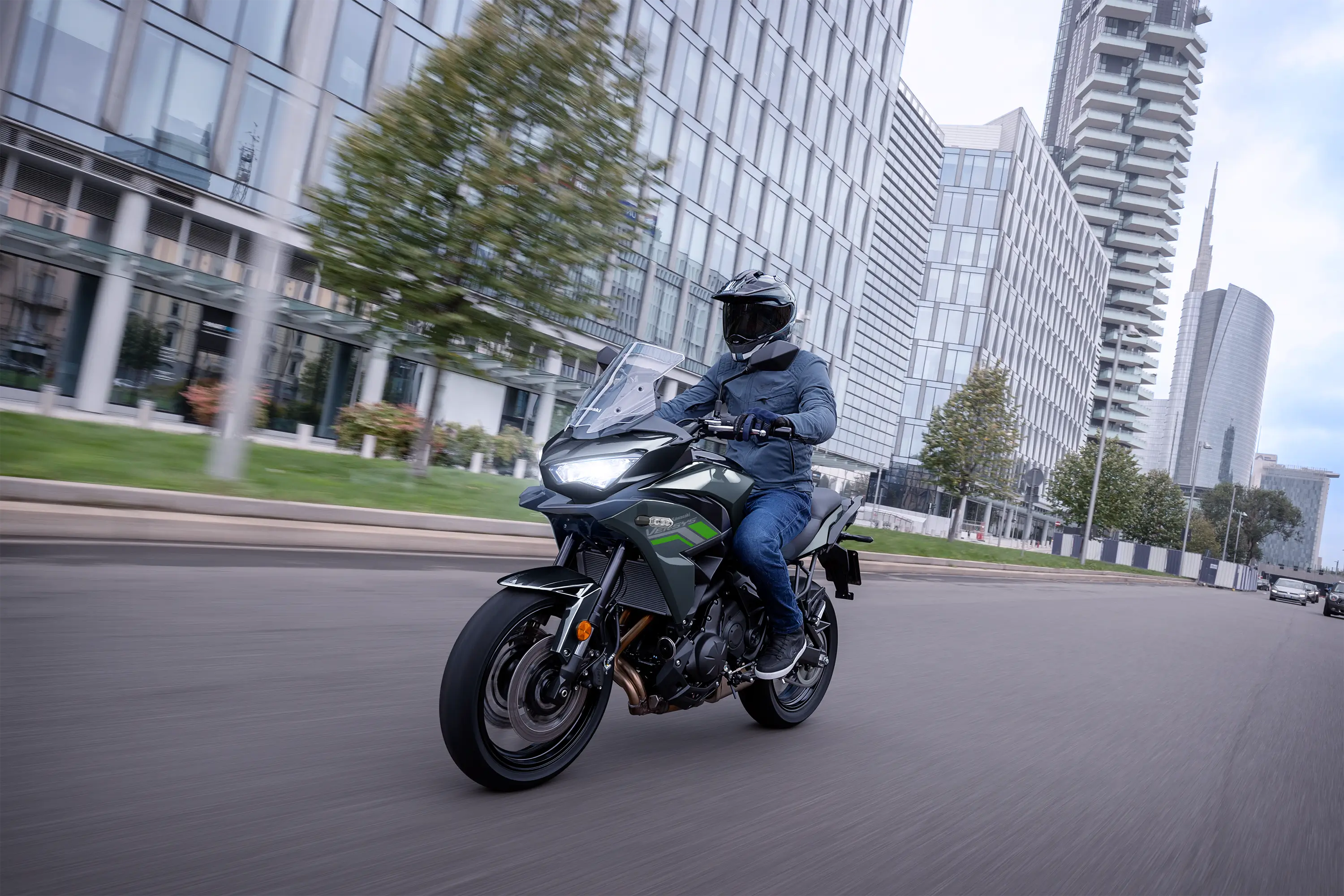 Three-quarter front angle of a person riding a motorcycle on the street.