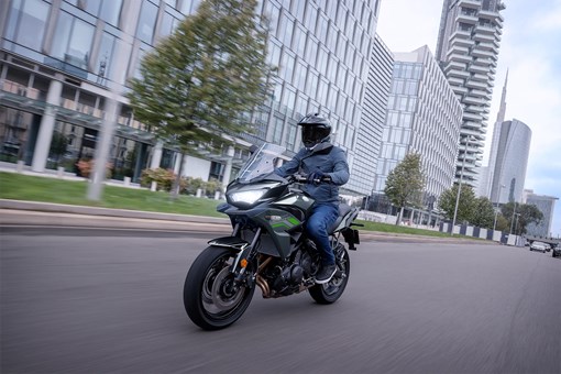 Three-quarter front angle of a person riding a motorcycle on the street. opens in a new window