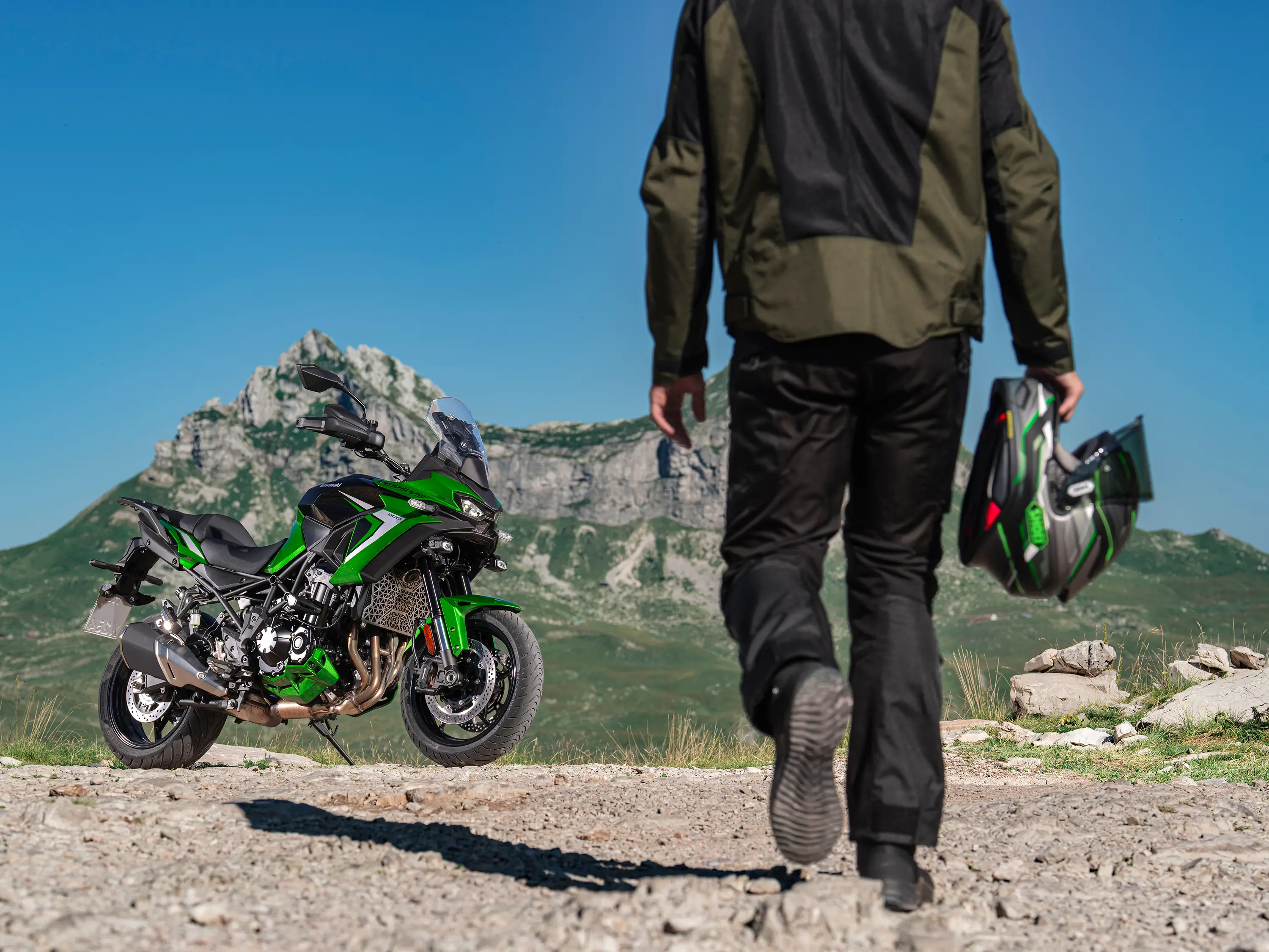Three-quarter front angle of a motorcycle parked and rider walking toward.