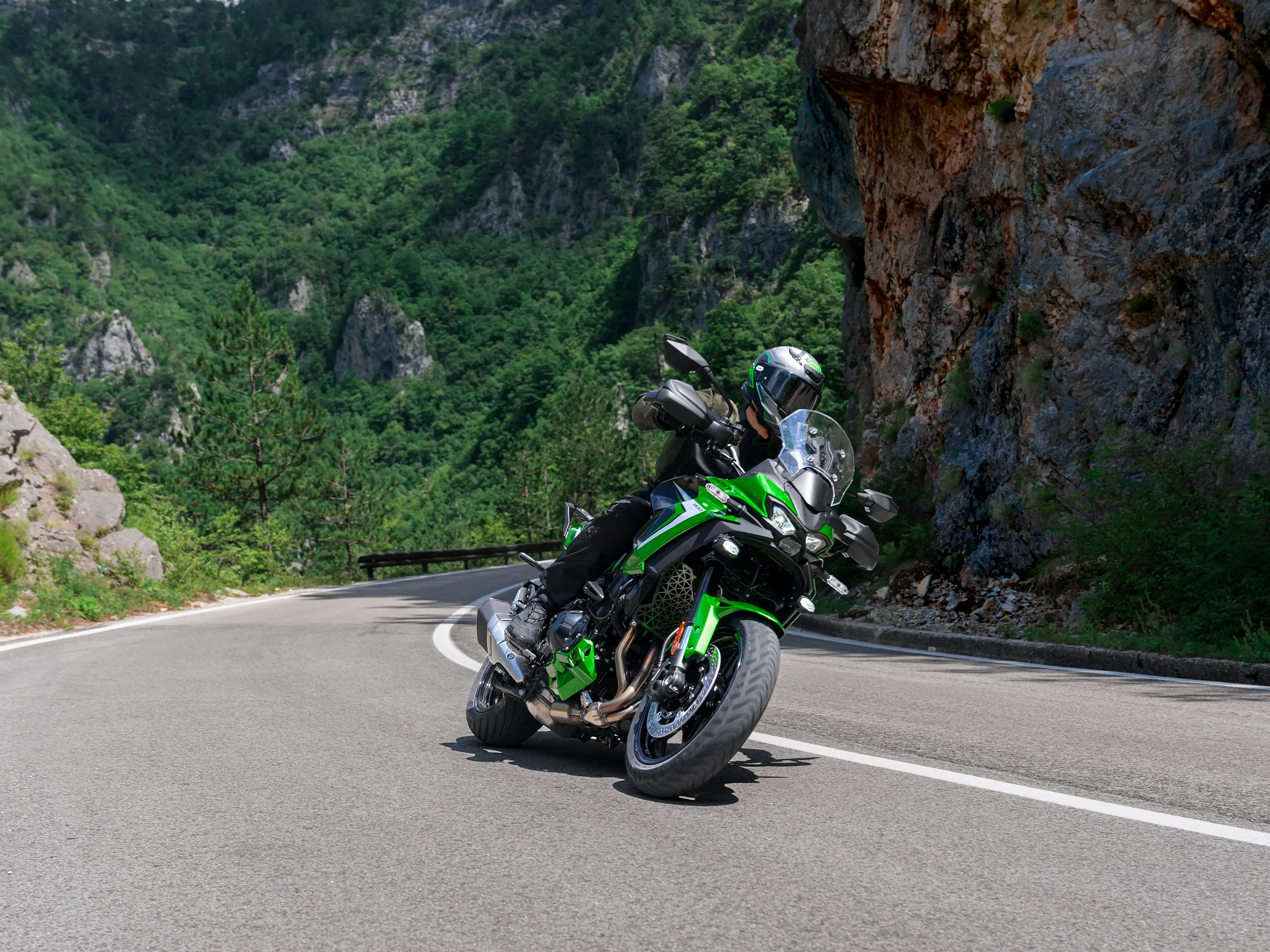 Three-quarter front angle of a person riding a motorcycle around a corner.