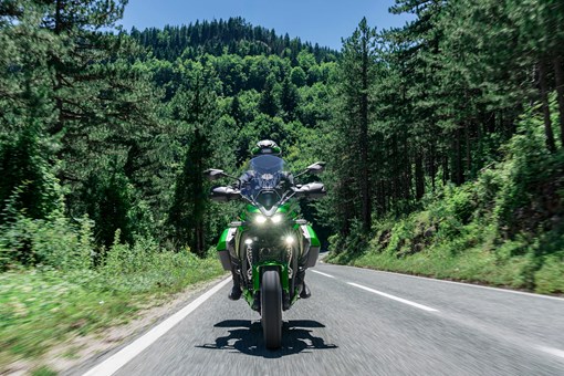 Front angle of a person riding a motorcycle on a highway. opens in a new window