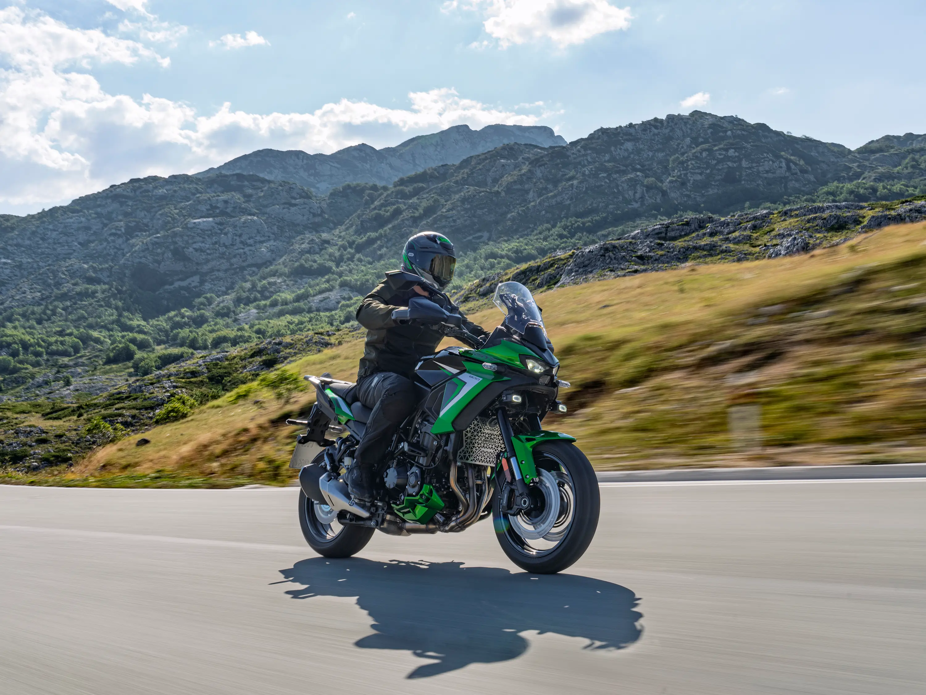 Side angle of a person riding a motorcycle on a highway.
