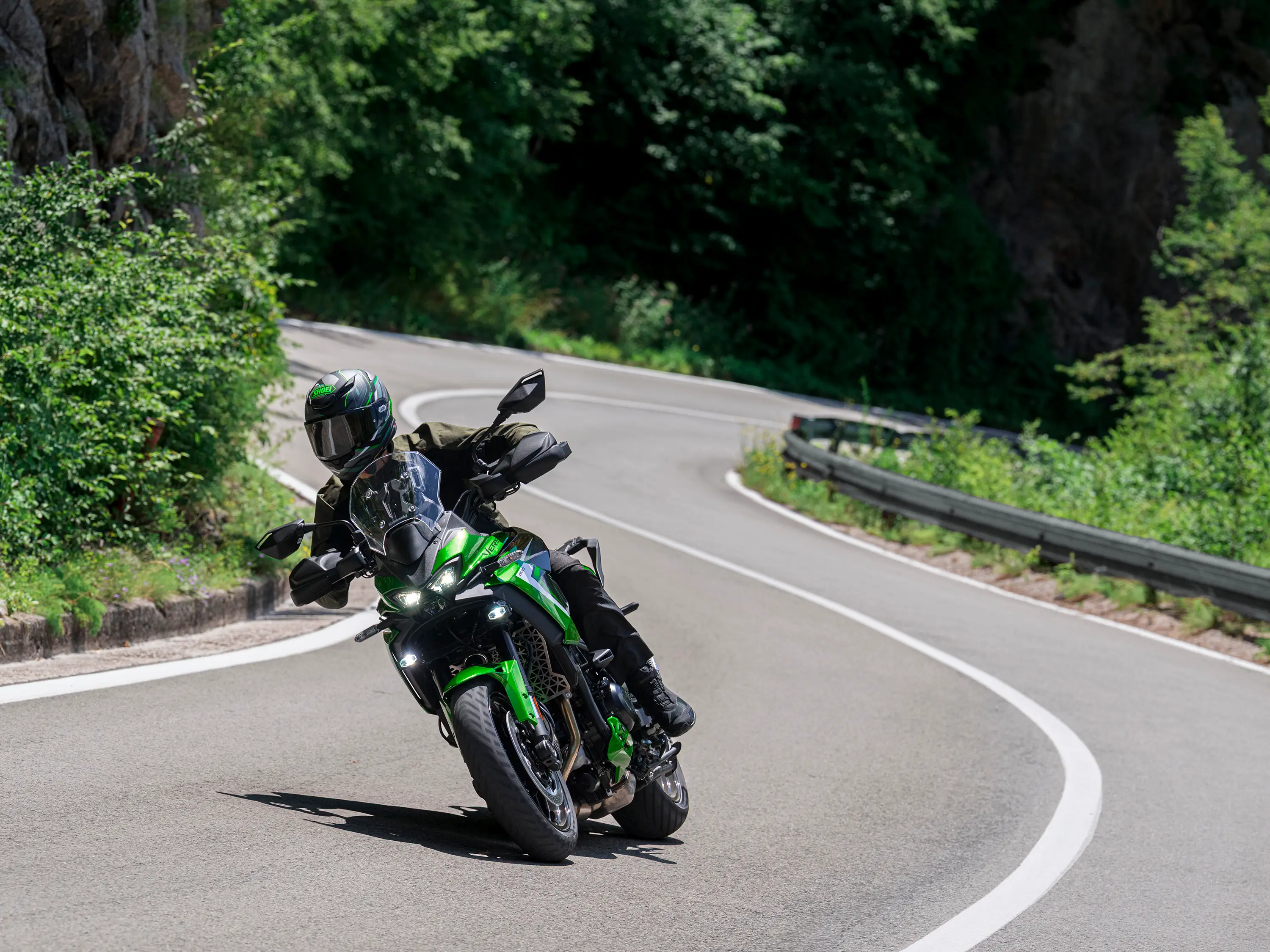 Three-quarter front angle of a person riding a motorcycle on a highway.