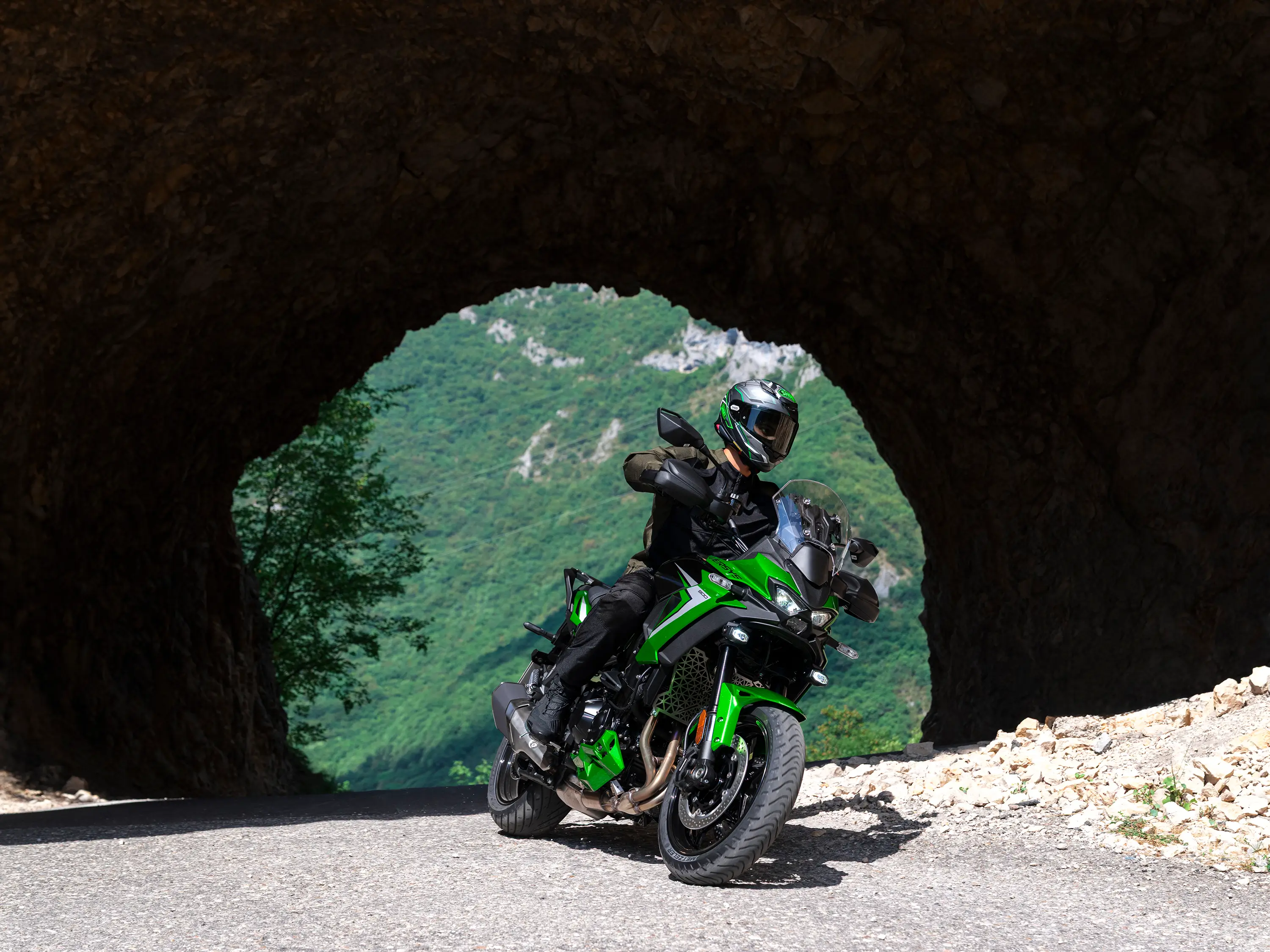 Three-quarter front angle of a person riding a motorcycle on a highway through a tunnel.