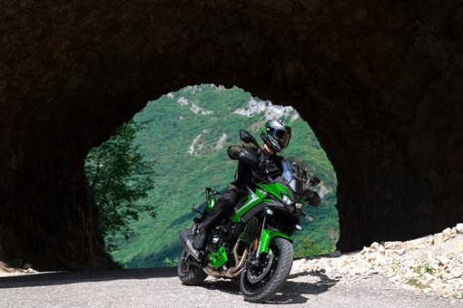 Three-quarter front angle of a person riding a motorcycle on a highway through a tunnel. opens in a new window