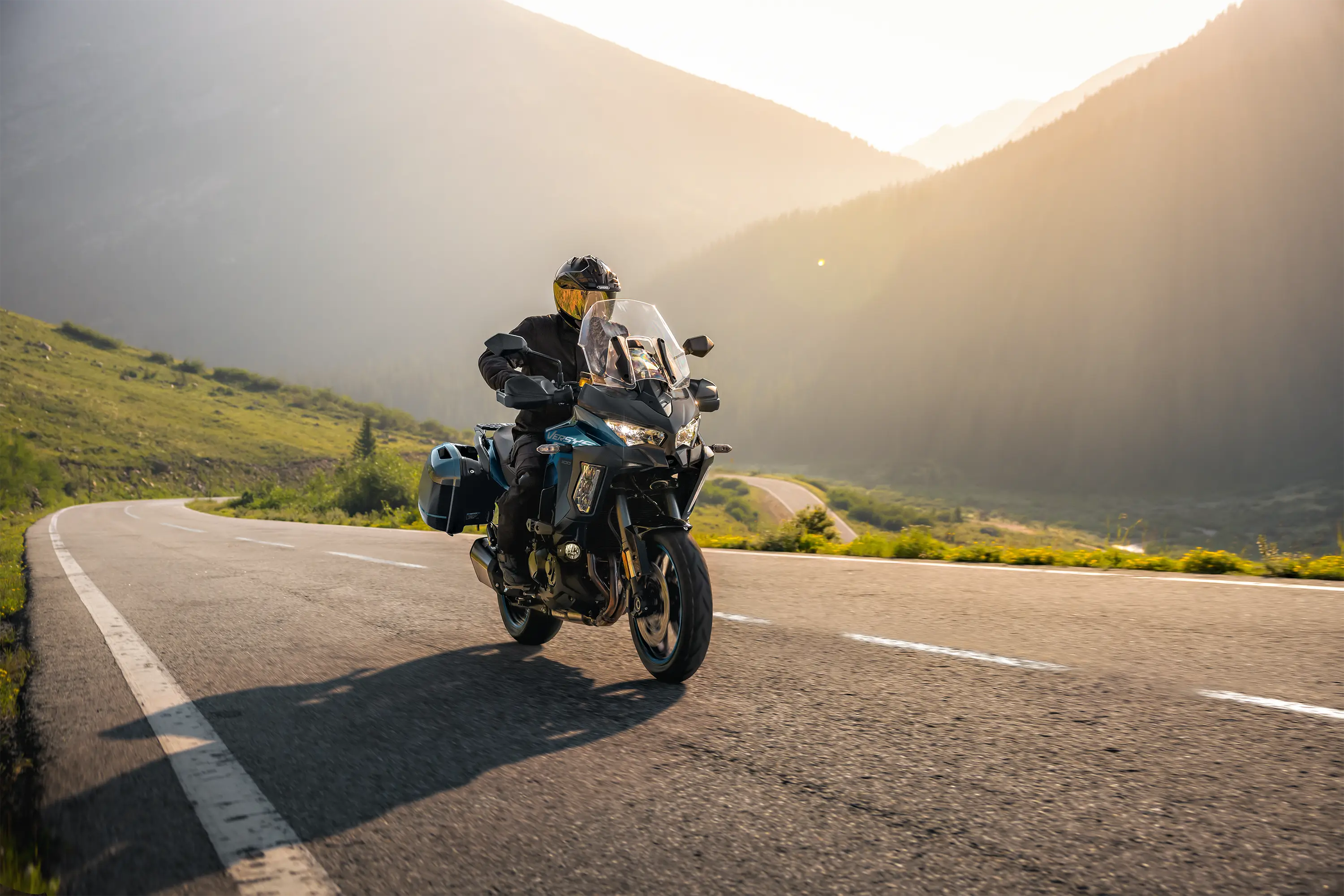 Three-quarter front angle of a person riding a motorcycle on a highway.