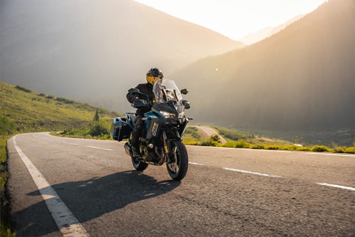 Three-quarter front angle of a person riding a motorcycle on a highway. opens in a new window