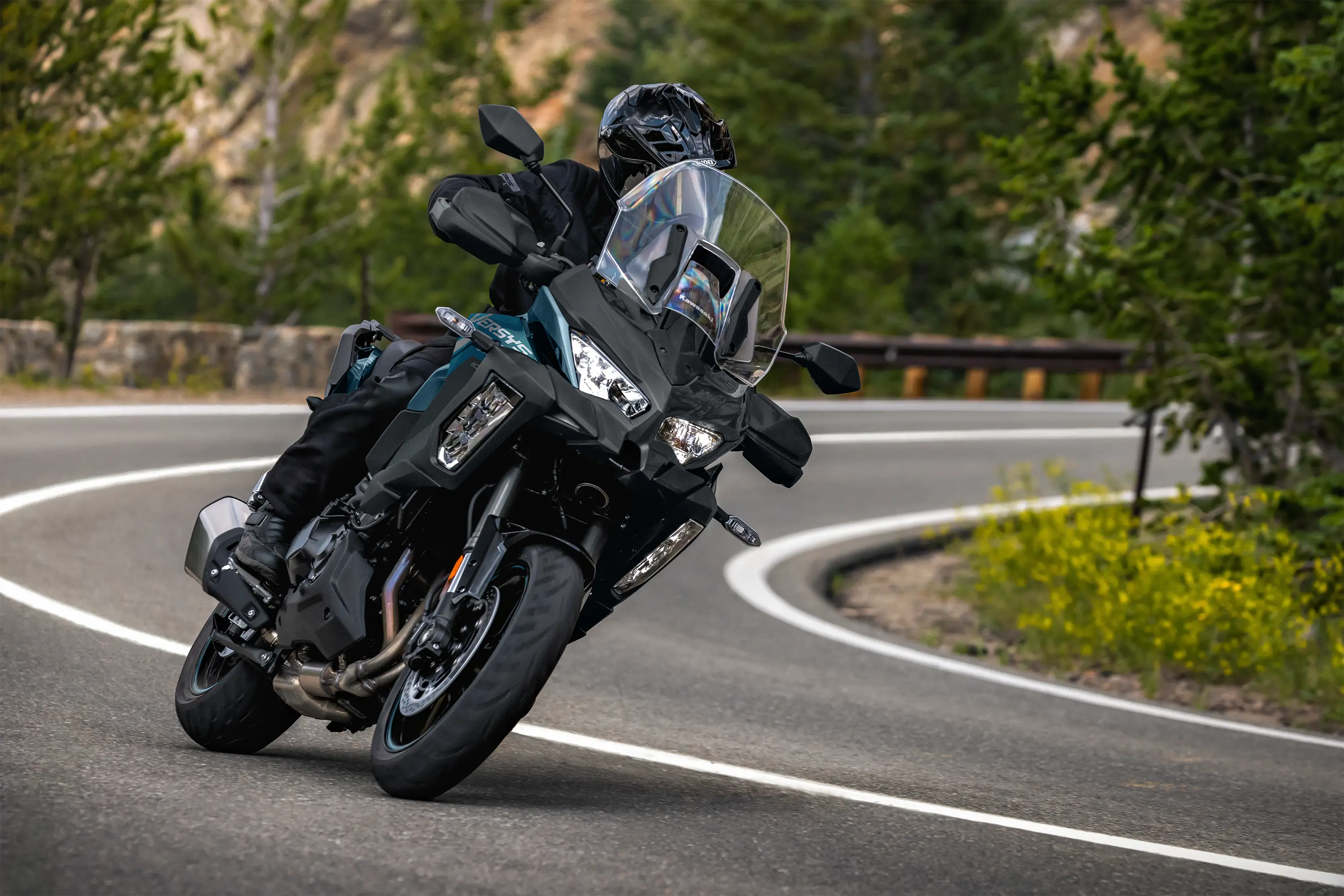 Three-quarter front angle of a person riding a motorcycle on a highway.