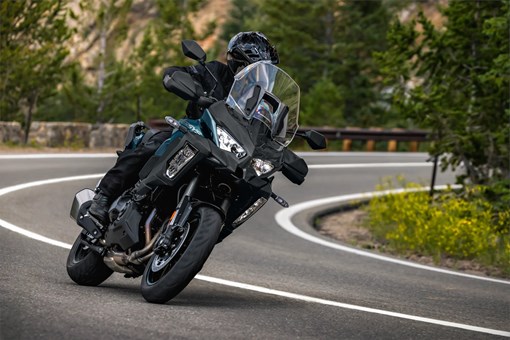 Three-quarter front angle of a person riding a motorcycle on a highway. opens in a new window