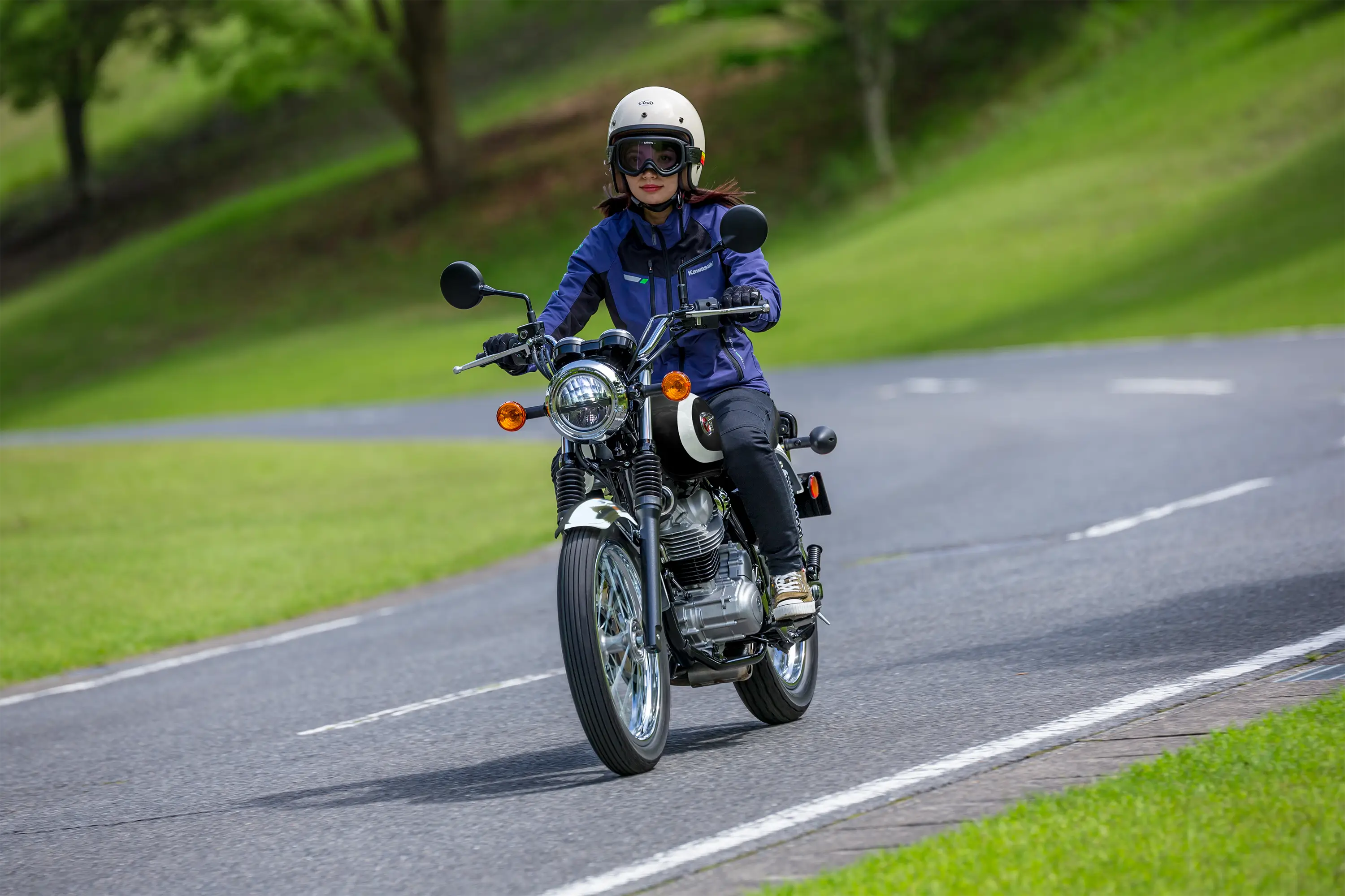 Three-quarter front angle of a person riding a motorcycle on a curvy road.