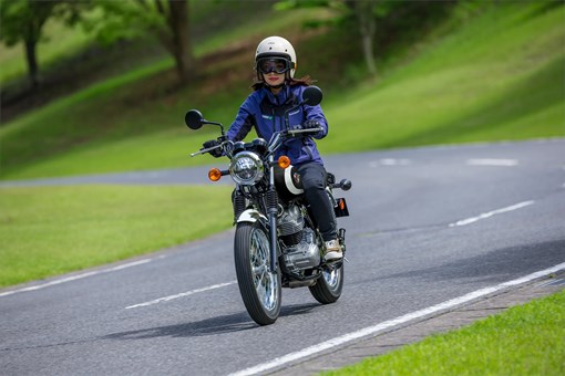 Three-quarter front angle of a person riding a motorcycle on a curvy road. opens in a new window