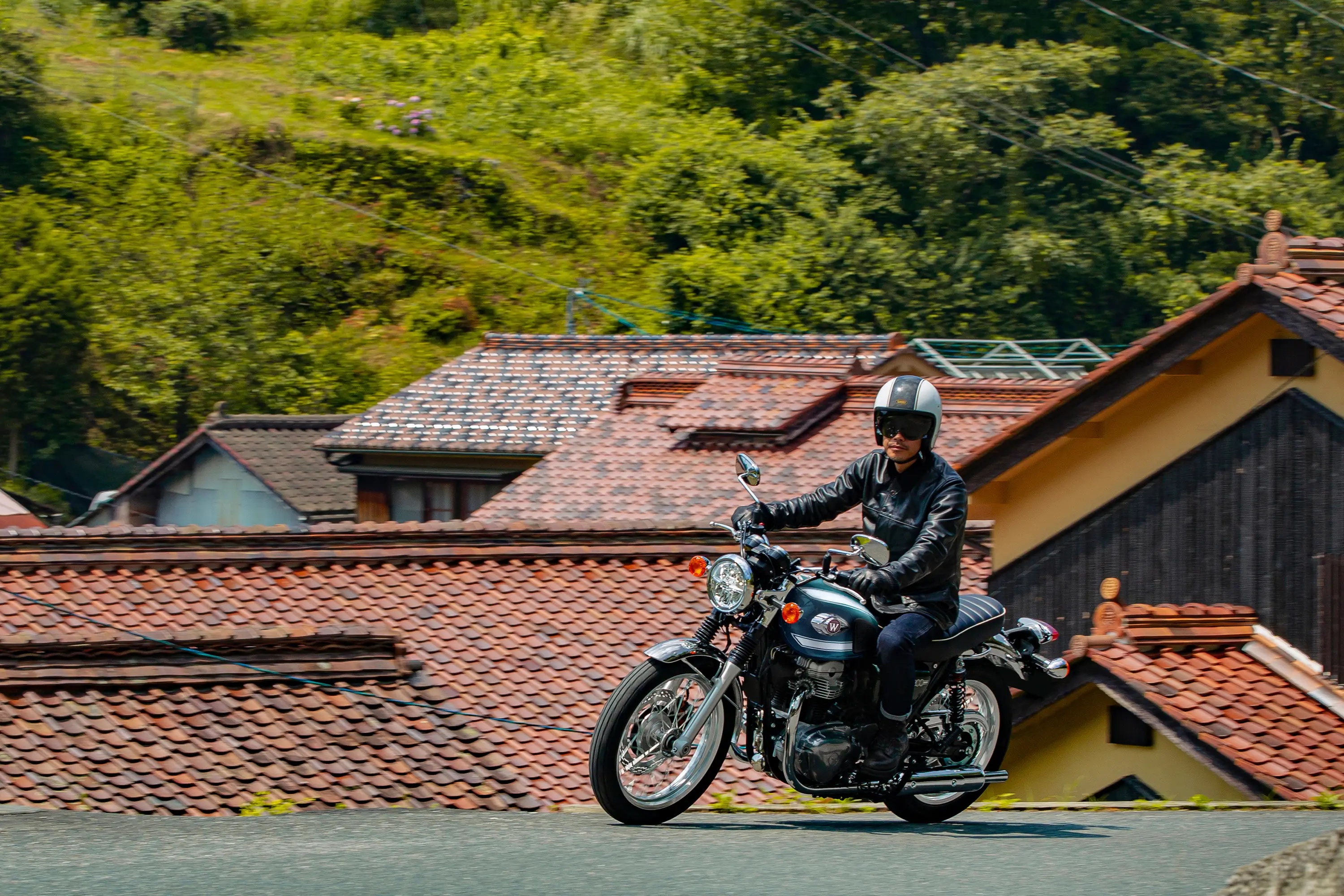 Side angle of a person riding a motorcycle on the street.