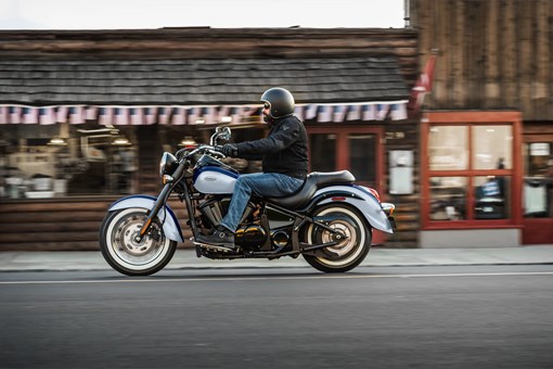 Side angle of a person riding a motorcycle on the street. opens in a new window