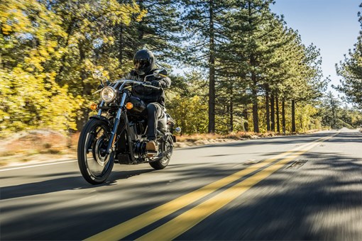 Front three-quarter angle of a person riding a motorcycle on a highway. opens in a new window