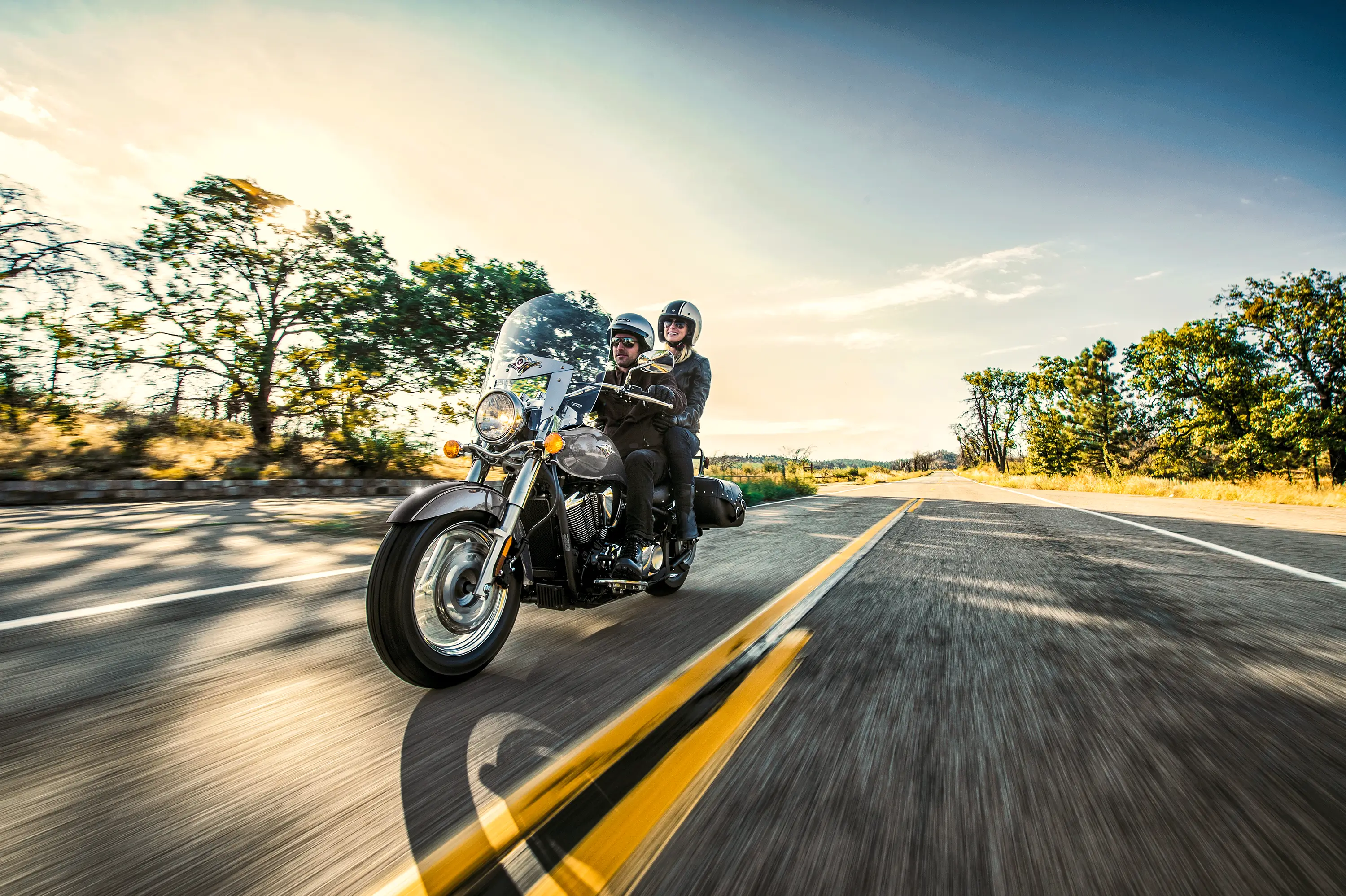 Three-quarter front angle of a person riding a motorcycle on a highway.