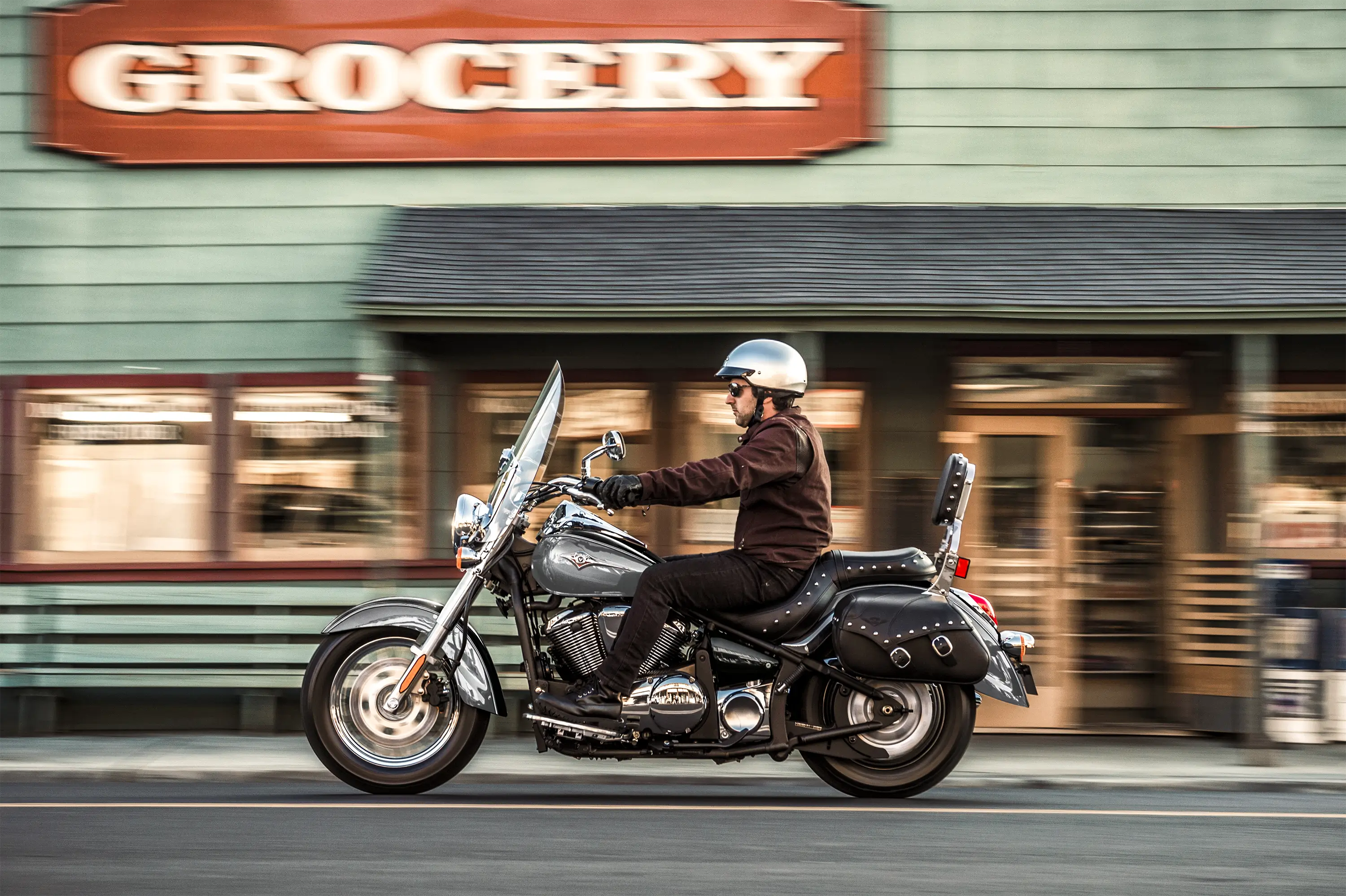 Side angle of a person riding a motorcycle on the street.