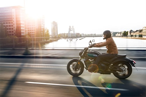 Side angle of a person riding a motorcycle on the street. opens in a new window