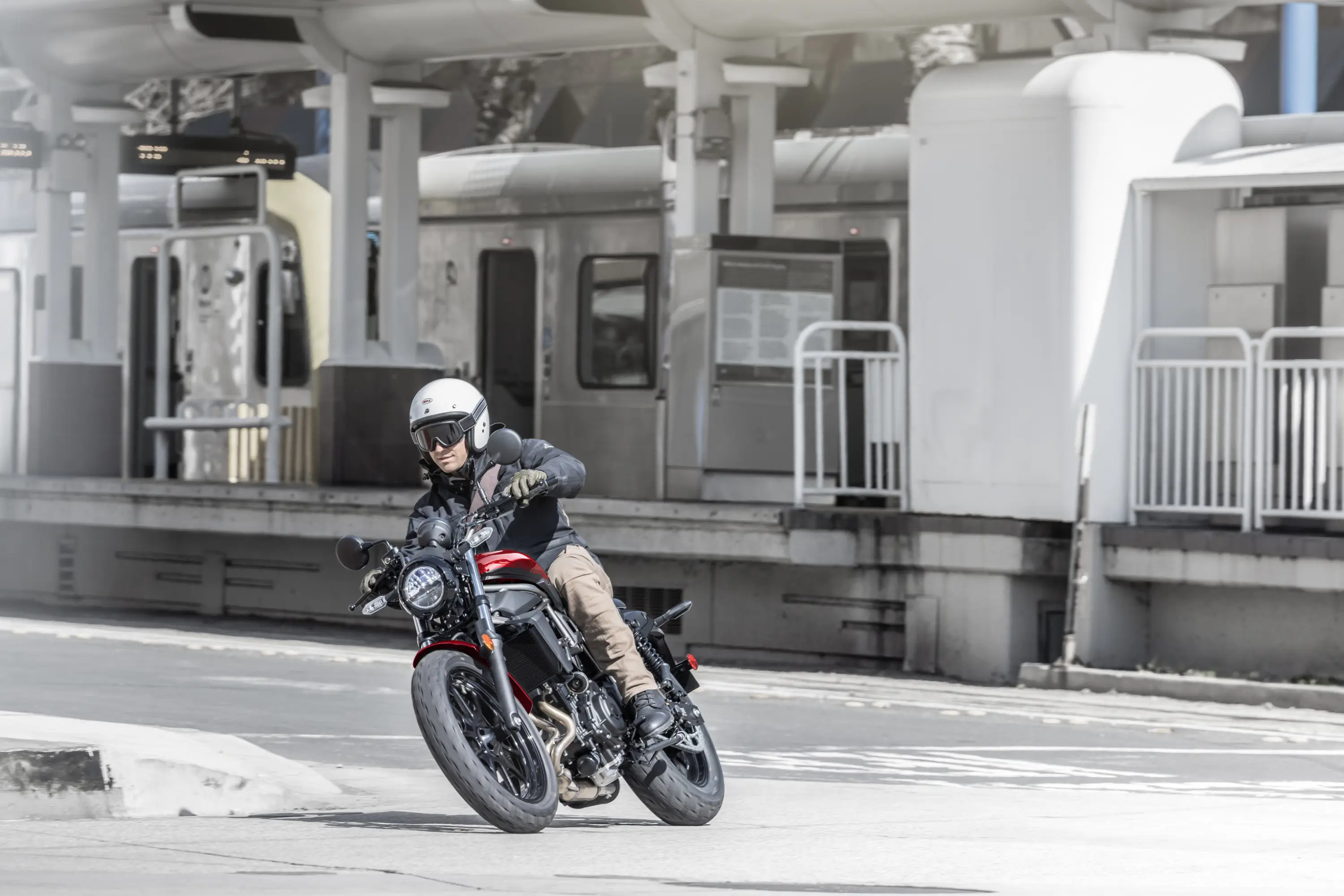 Front three-quarter angle of a person riding a motorcycle on the street.