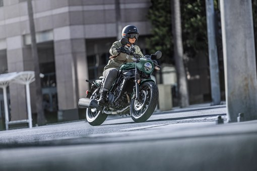 Three-quarter front angle of a person riding a motorcycle downtown. opens in a new window