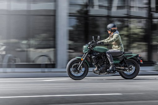 Side angle of a person riding a motorcycle on the street. opens in a new window