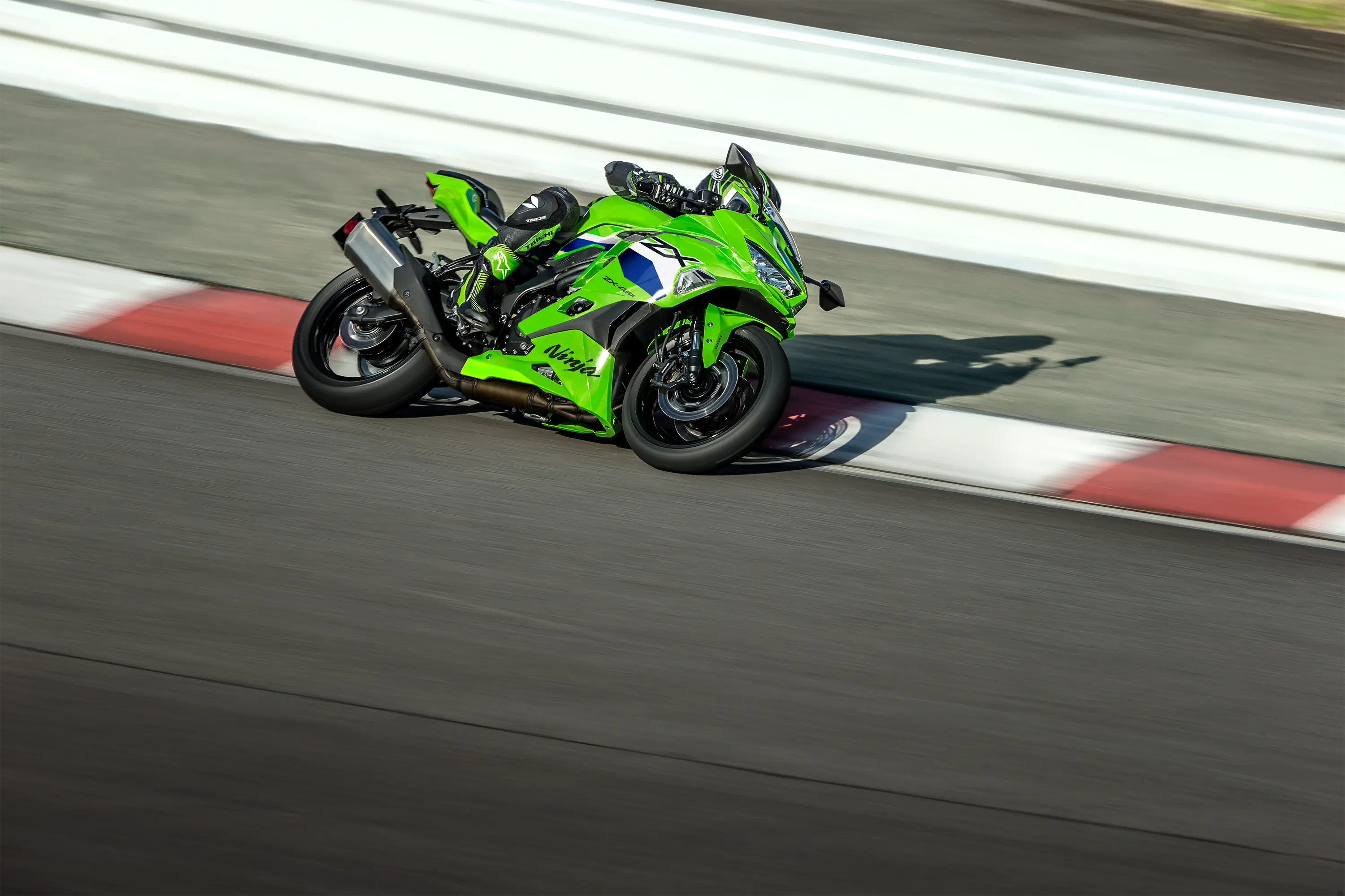 Side angle of a person riding a motorcycle and turning on a racetrack.