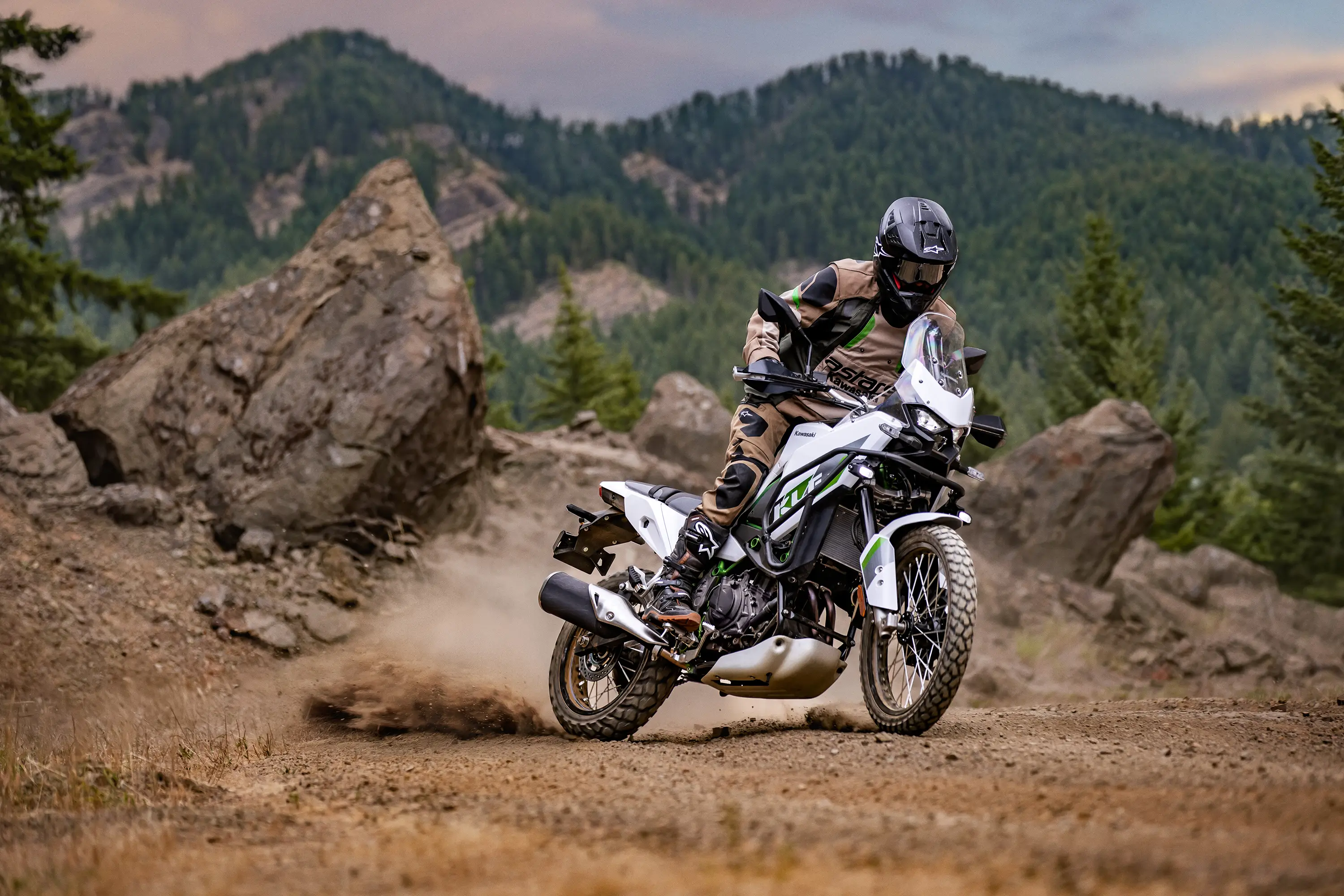 Side angle of a person riding a motorcycle off-road.