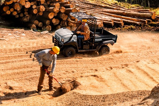 Side angle of a person driving a side x side on a job site. opens in a new window