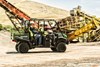 Side angle of a person driving a side x side on a job site.