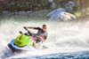 Three-quarter front angle of a person on a personal watercraft on the water. 