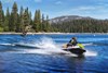 Three-quarter front angle of two people on a personal watercraft on the water. 