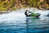 Side angle of a person on a personal watercraft on the water.