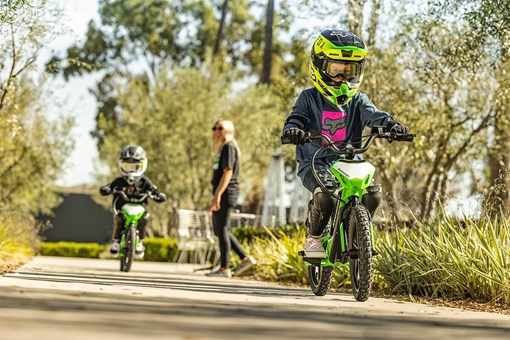 Front angle of two children riding an electric balance bike. opens in a new window