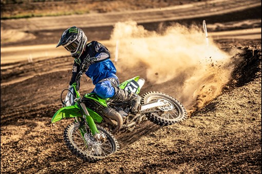 Three-quarter front angle of a person throwing roost coming out of a corner on a track. opens in a new window