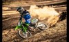 Three-quarter front angle of a person throwing roost coming out of a corner on a track.