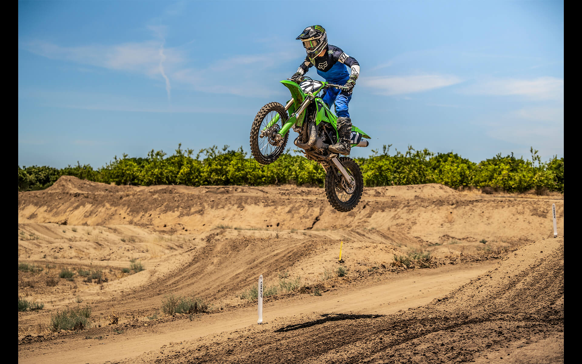 Three-quarter front angle of a motorcycle in the air on a track.