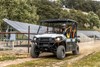Three-quarter front angle of a person driving a side x side off-road.