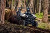 Three-quarter front angle of a person and passenger driving a side x side off-road.