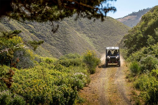 Front angle of a person driving a side x side off-road. opens in a new window